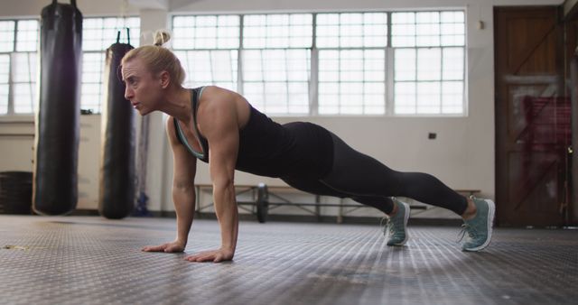 Fit caucasian woman performing push up exercise at the gym. sports, training and fitness concept