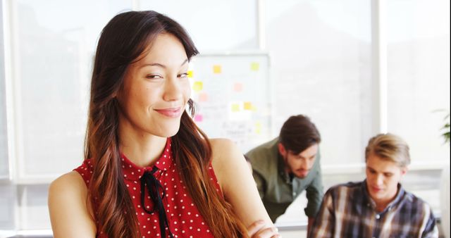 Confident Businesswoman at Office with Colleagues in Background - Download Free Stock Images Pikwizard.com