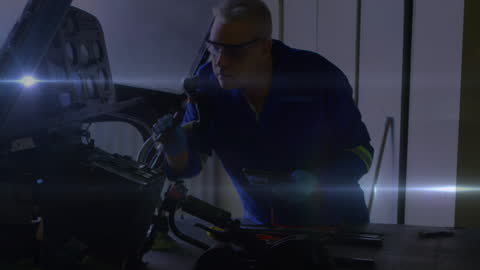 Focused Mechanic Performing Vehicle Maintenance with Light Effects