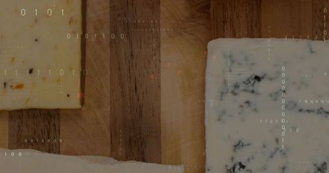 Artisanal cheese trio on rustic wood board with crumbs, herbs and digital binary overlay