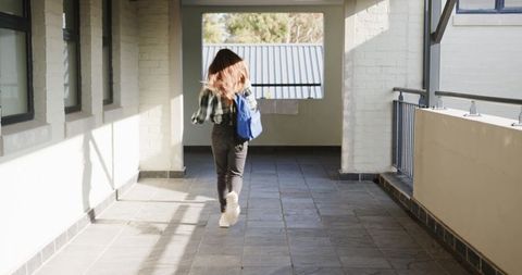 Student Walking Down Casual Outdoor Corridor