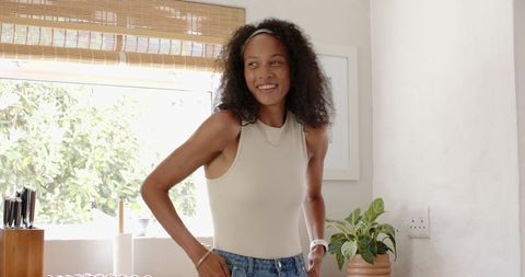 Smiling woman preparing vegetables in natural light kitchen