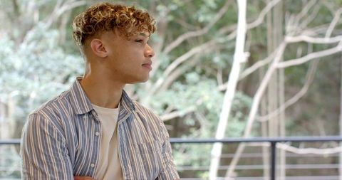 Youth contemplates outdoors on a scenic balcony