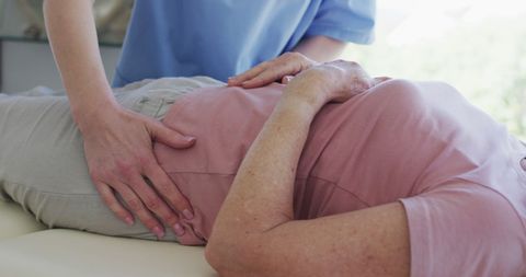 Physical Therapist Performing Pelvic Massage on Senior Woman