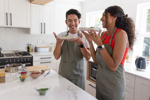 African american couple sharing laughter savoring home-cooked meal in modern kitchen