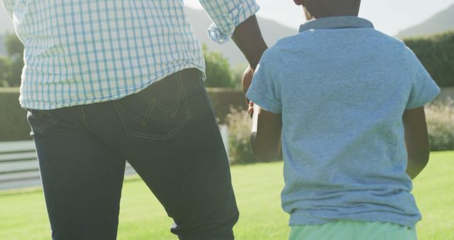 Father and son holding hands walking in park on sunny day - Download Free Stock Images Pikwizard.com