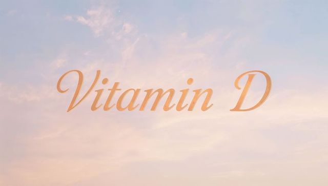 Sunlit Vitamin D lettering over pastel sunrise sky with soft wispy clouds