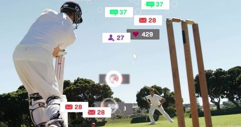 Cricket batsman swinging to hit red ball with social media notification overlay on sunny field