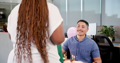 Colleagues Exchanging Gifts During Team Celebration in Office