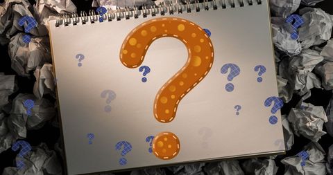 Colorful question marks on notepad with crumpled papers