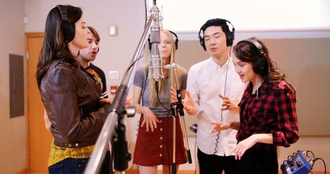 Confident Group of Singers Collaborating in Modern Recording Studio