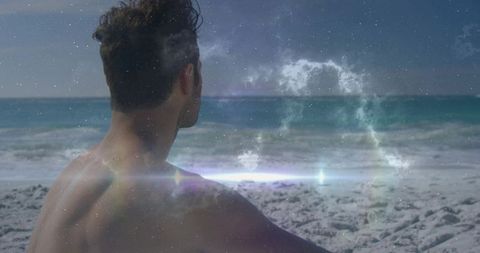 Shirtless man watching ocean horizon with cosmic nebula overlay and lens flare