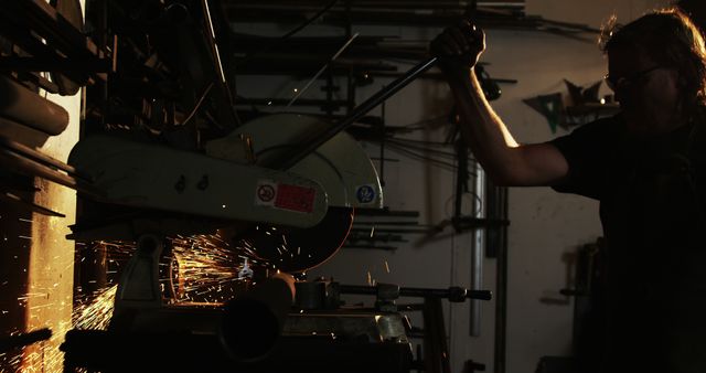 Worker Cutting Metal with Circular Saw in Dark Workshop - Download Free Stock Images Pikwizard.com