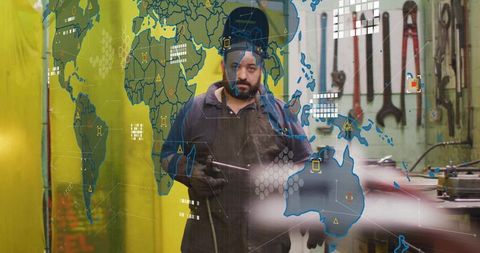 Metalworker Welding with Digital World Map Interface Overlay