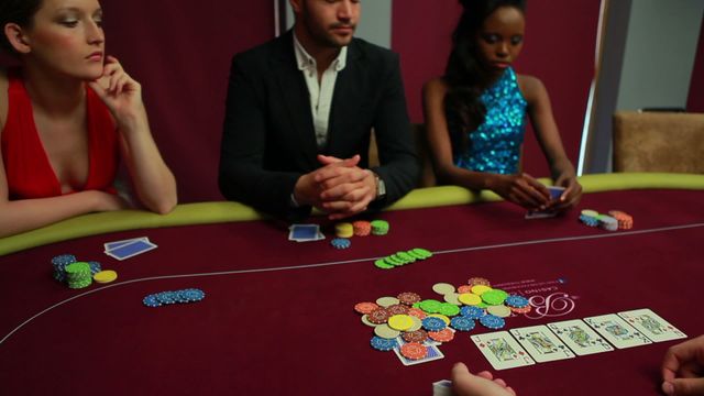 People are engaging in a poker game at a casino, concentrating on their hands and strategically placing bets with poker chips on a velvet table. A variety of colorful chips and playing cards are visible, showcasing an atmosphere of competition and focus. This scene can depict themes of gaming strategy, decision making, and high-stakes risk perfect for illustrating gambling environments or for concepts related to mental acuity and strategic planning.