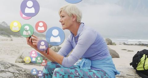 Senior woman engaging with social media on seaside