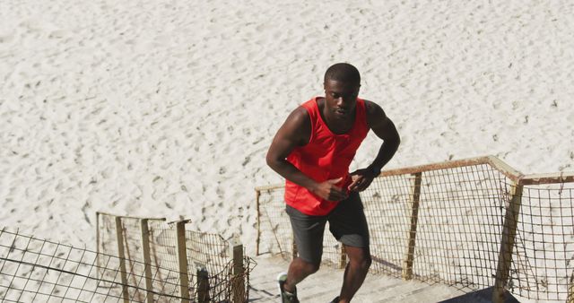 Focused african american man running, exercising outdoors by the seaside. fitness, healthy and active lifestyle concept.
