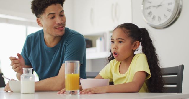 Happy biracial father and daughter eating breakfast together - Download Free Stock Photos Pikwizard.com