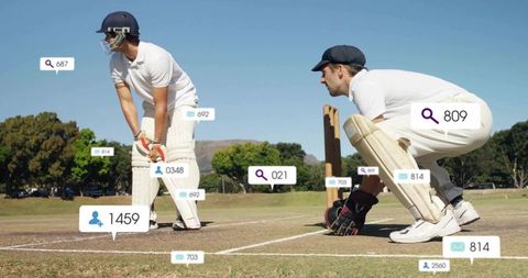 Cricket Players Analyzing Strategy with Digital Icons on Field