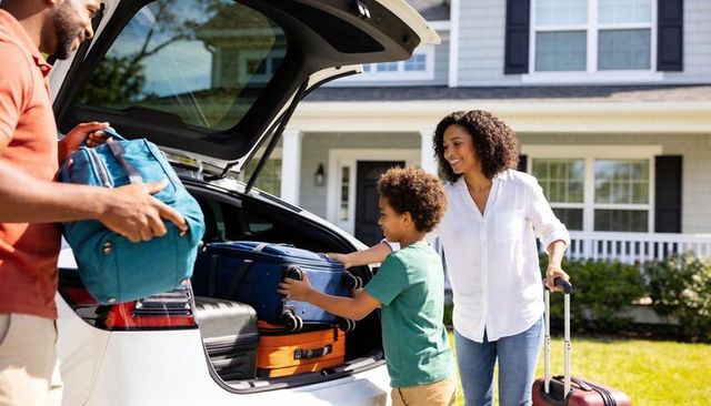 Family packing car with luggage for suburban road trip and weekend getaway