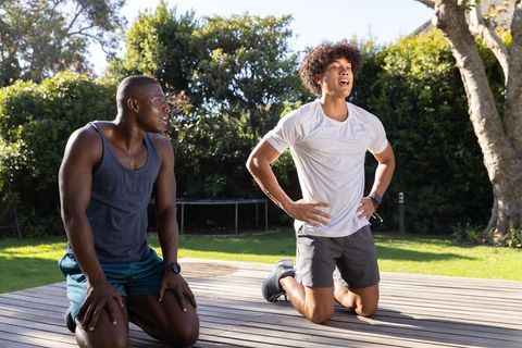 Friends relaxing post-workout outdoors in sunny garden