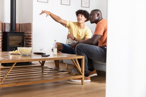 Diverse Male Friends Relaxing in Cozy Living Room with Popcorn