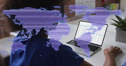 Data analyst evaluating global trends on laptop in modern workspace