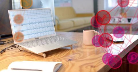 Modern workspace with laptop displaying spreadsheet and network overlay