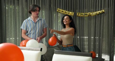 Happy Couple Decorating with Balloons for Birthday Celebration