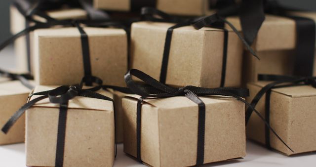 Brown gift boxes with black ribbons on dark grey background. Luxury treat, present, shopping, black friday sale and retail concept digitally generated image.