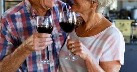 Happy Senior Couple Toasting with Red Wine at Home