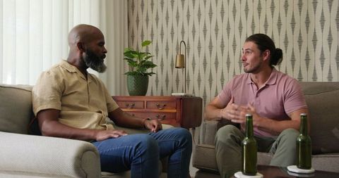 Two Friends in Deep Conversation with Drinks in Cozy Living Room