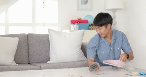 Man Preparing Living Room for Festive Celebration with Balloons