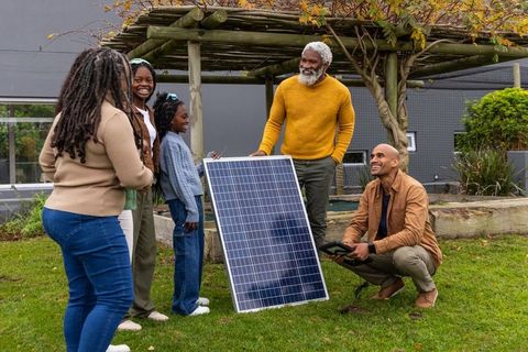 Multigenerational african american family testing solar panel for home renewable energy