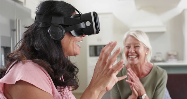 Laughing Woman Experiencing Virtual Reality with Friend in Modern Kitchen - Download Free Stock Images Pikwizard.com