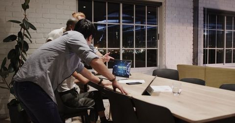 Diverse team collaborating on night project in modern office