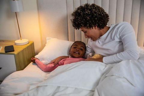 Mother Snuggling Daughter in Bed with Warmth and Care