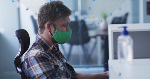 Data analyst wearing green mask working with numerical data in modern office