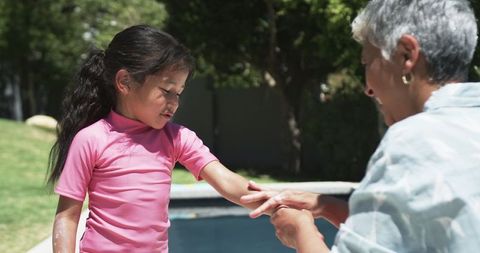 Grandmother Sharing Teaching Moment with Biracial Granddaughter Outdoors