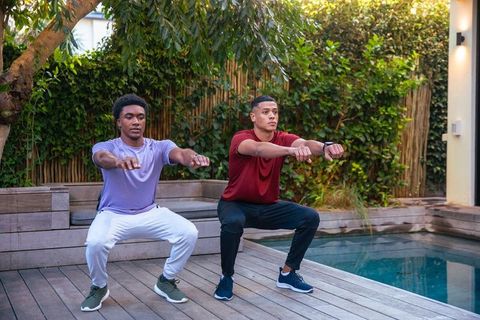 Diverse men exercising with squats outdoors by pool