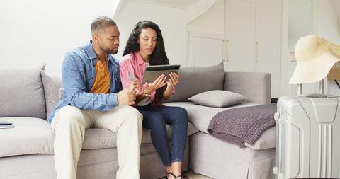 Couple Planning Vacation with Tablet at Home