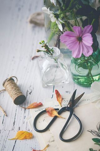 Rustic floral arrangement with vintage scissors on white wood table