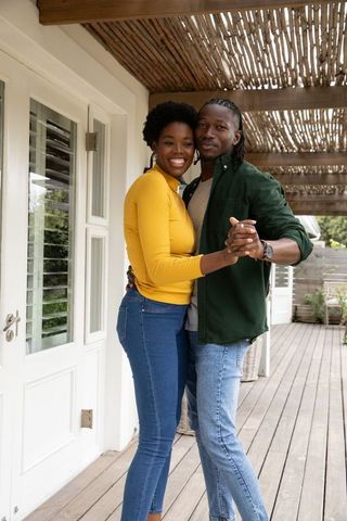 Happy African American Couple Dancing on Stylish Rustic Deck