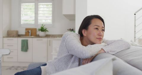 Thoughtful Woman Relaxing on Sofa in Modern Home - Download Free Stock Images Pikwizard.com