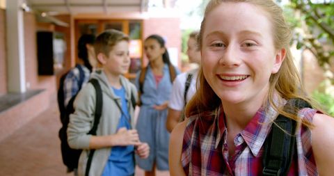 Smiling Schoolgirl Enjoys School Day with Friends in Background - Download Free Stock Images Pikwizard.com