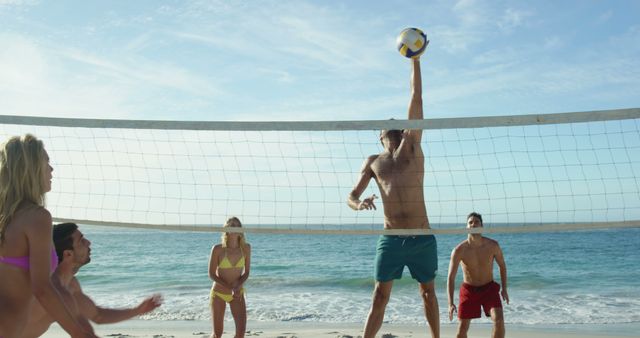 Group of friends enjoying a game of beach volleyball under bright sun. Perfect for use in promotions for summer activities, beach products, vacation packages, fitness campaigns, and outdoor lifestyle advertisements.