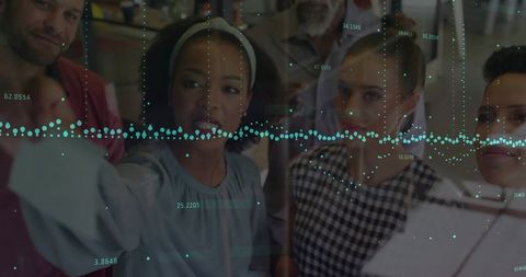 Team Analyzing Data on Glass Panel in Modern Office