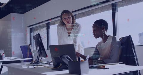 Diverse Women Collaborating on Laptop in Modern Office