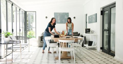 Friends Preparing Dining Table for Graduation Celebration