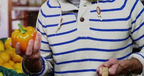 Casual Shopper Examining Fresh Orange Pepper in Grocery Aisle